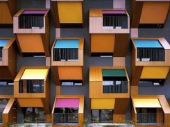 la facciata di un palazzo caratterizzata dalle tende di colori diverse sui balconi
