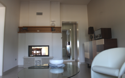 un soggiorno moderno con termocamino: uno degli elementi che contribuiscono alla qualificazione energetica di una casa, per la redazione dell'APE