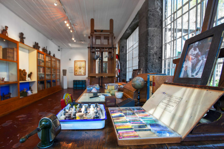 Lo studio Casa Azul. Coyoacán , Città del Messico, Messico - sul tavolo a destra vi sono colori, una foto di Rivera; sulla sinistra una libreria 
