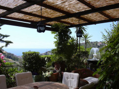 come arredare il terrazzo: tavolo e sedie con stuoia per riparare dal sole