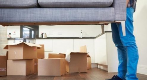 immagine trasloco casa: scatoloni e divano portato da 2 persone