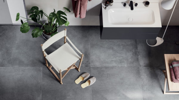 bagno realizzato in stile minimalista, con arredi essenziali e pavimento e rivestimenti in materiali in linea con lo stile